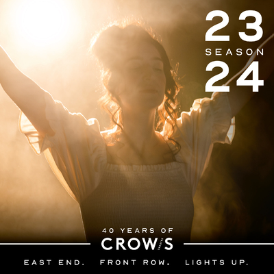 2023.24 Season Cover Image: woman in white dress with arms in the air, lit from behind with a haze in the air