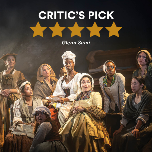 Group of twelve women dressed in 18th-century-style costumes, including bonnets, shawls, aprons, and gowns, posed on stage with warm lighting and a wooden structure in the background. Above them are five gold stars and the text “CRITIC’S PICK” in bold white letters, with “Glenn Sumi” written underneath.